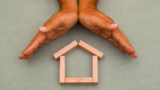 Hands enclosing wooden house1