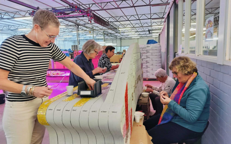 Buurtbewoners werken aan mozaiekbankje1