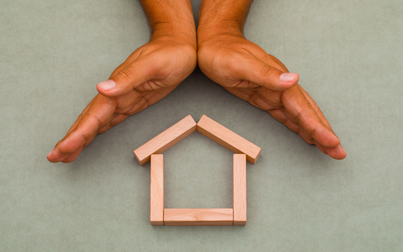 Hands enclosing wooden house1