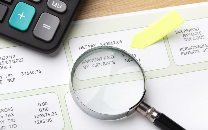 Payroll still life with magnifying glass