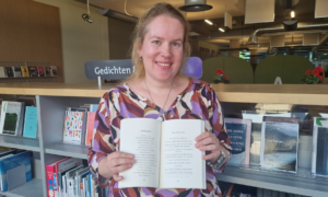 Laura Nijenbrink met haar dichtbundel 'Som is het heel dichtbij'