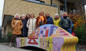 Barbara Fransen haar zussen bewoners Lonneker Steumke en medewerkers DCW bij het Ferdinand Fransen Enschede700 mozaiekbankje
