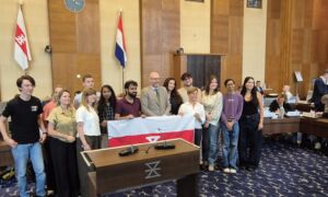 Groepsfoto overhandiging vlag van Enschede in raadszaal
