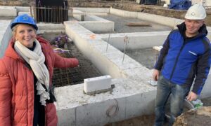 Koper Anke en uitvoerder Tim Braakhuis bij de eerste steen van Wemen Weelde in Hengelo