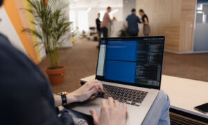 Close up man writing code laptop