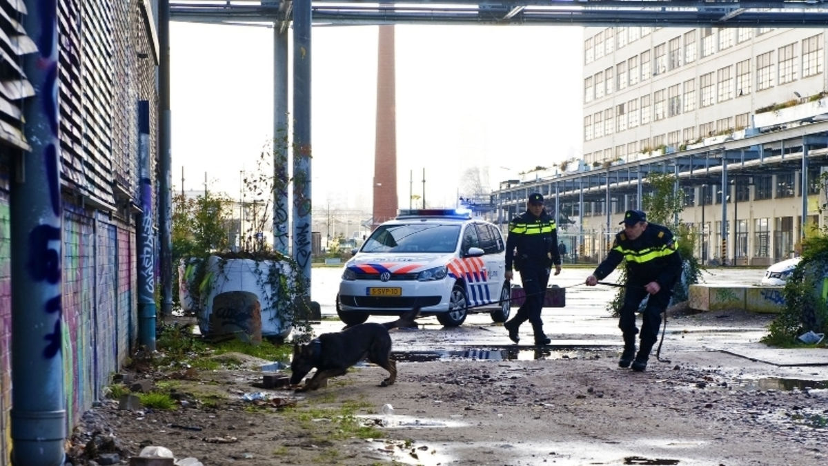Agenten speuren met diensthond bij fabrieksterrein foto van politie