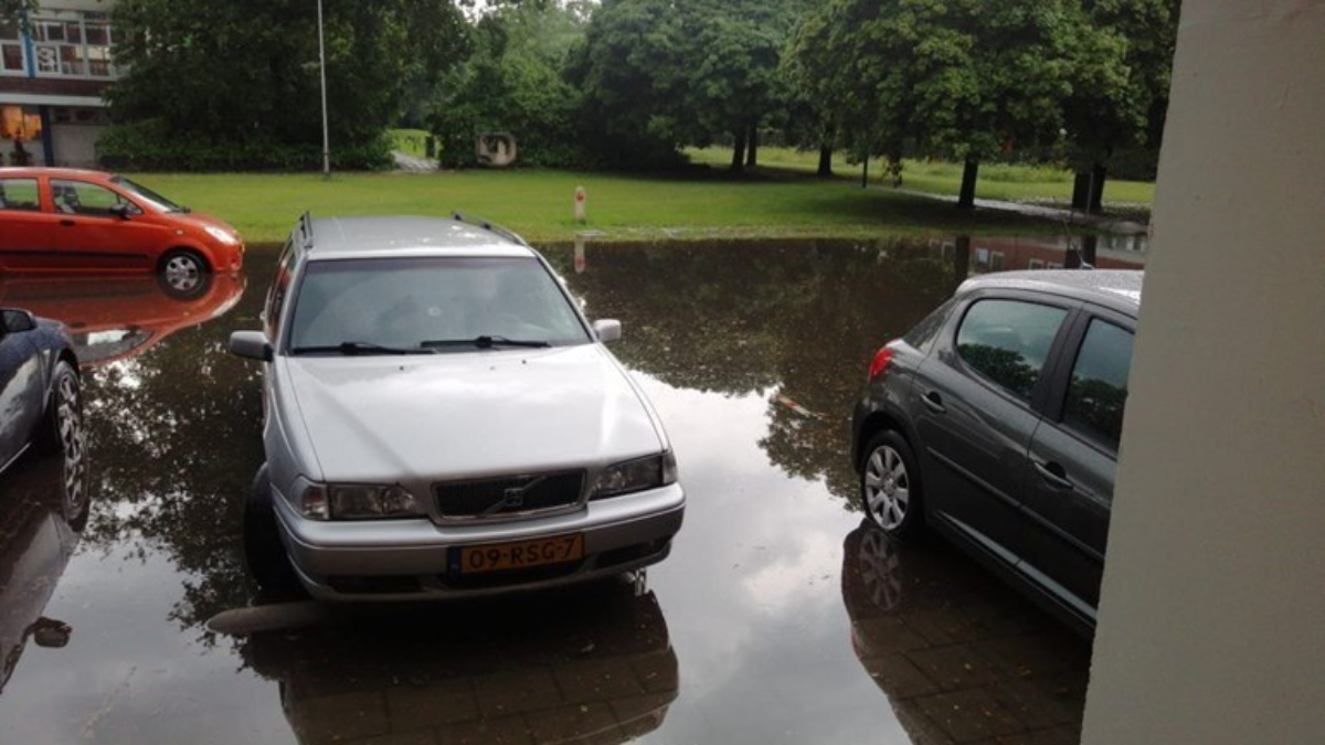 Parkeerplaatsen onder water aan de Weusthagstraat in Hengelo Foto RTV Oost