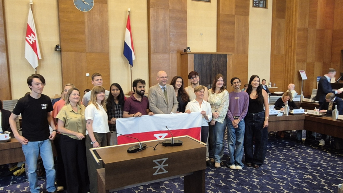 Groepsfoto overhandiging vlag van Enschede in raadszaal