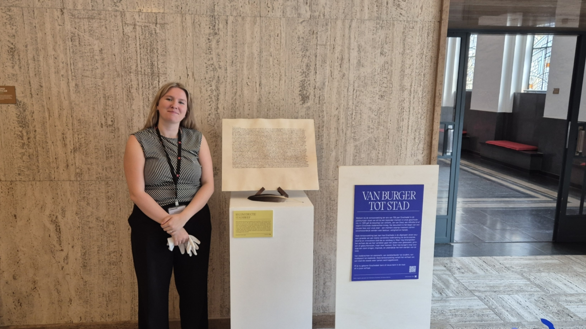 Meg Slot naast de replica van de stadsrechtenbrief van Enschede