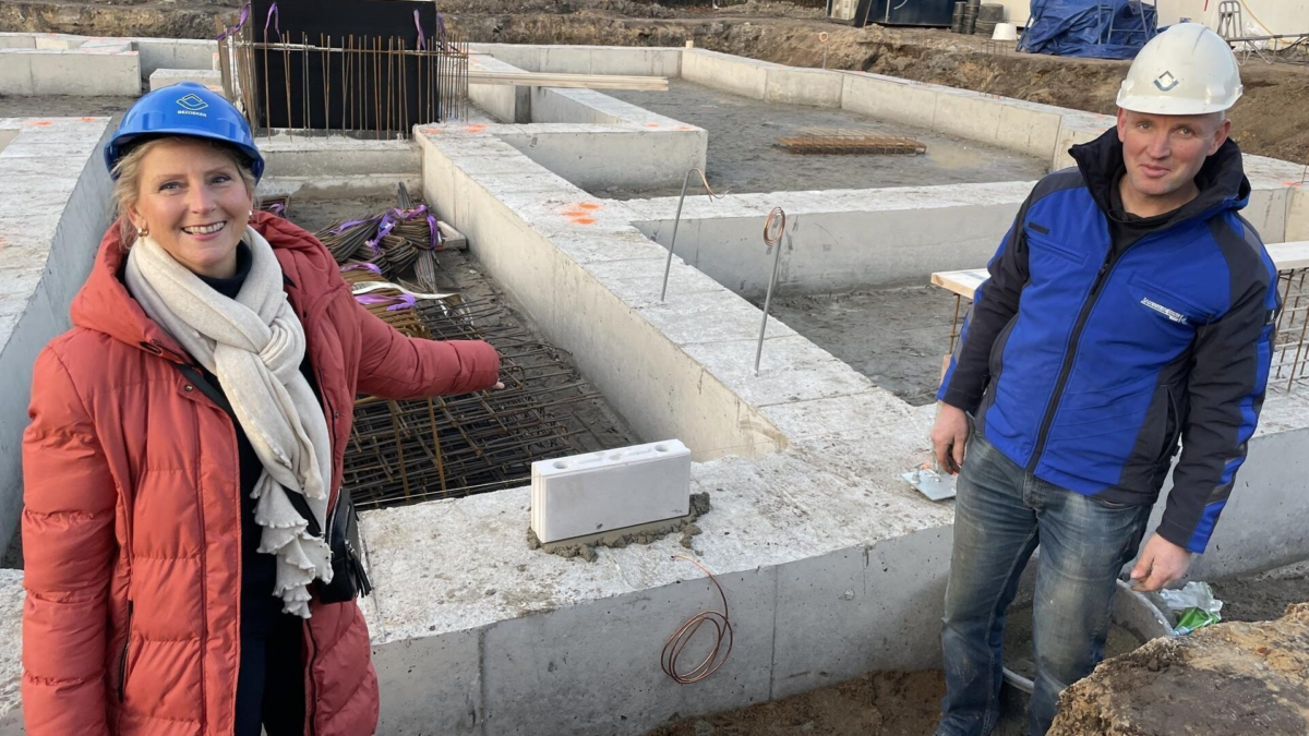 Koper Anke en uitvoerder Tim Braakhuis bij de eerste steen van Wemen Weelde in Hengelo