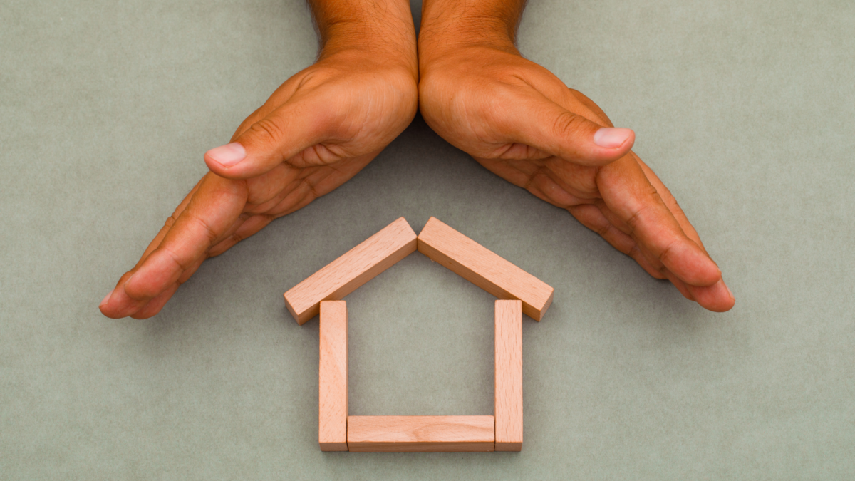 Hands enclosing wooden house1