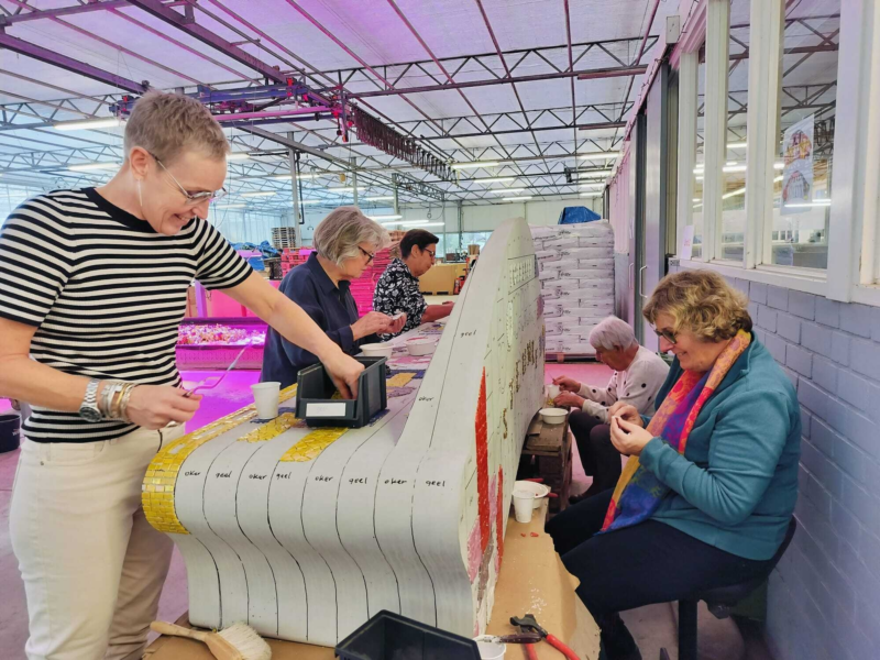 Buurtbewoners werken aan mozaiekbankje1