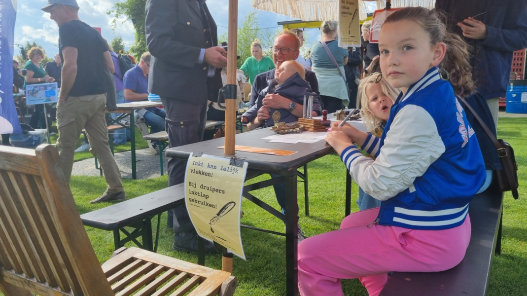 Meisje schrijft kaart voor familie tijdens festival